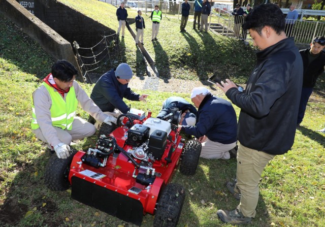 Directorate of Public Works personnel take a closer look at a Sanyokiki remote-controlled lawn mower at Camp Zama, Japan, Dec. 6, 2024. DPW crews plan to use the mower to cut grass on the facility's steep hills.