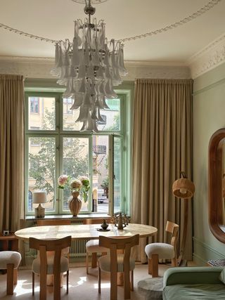 a dining table with a Murano glass floral chandelier above