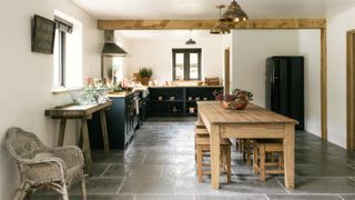 Slate kitchen floor in a farmhouse kitchen with a light wall and wooden beams