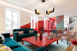 a living-dining room with red painted walls