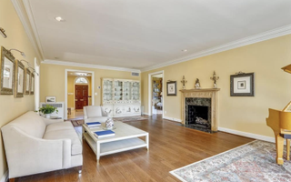 A living room with a white couch, yellow sofas and wooden floors