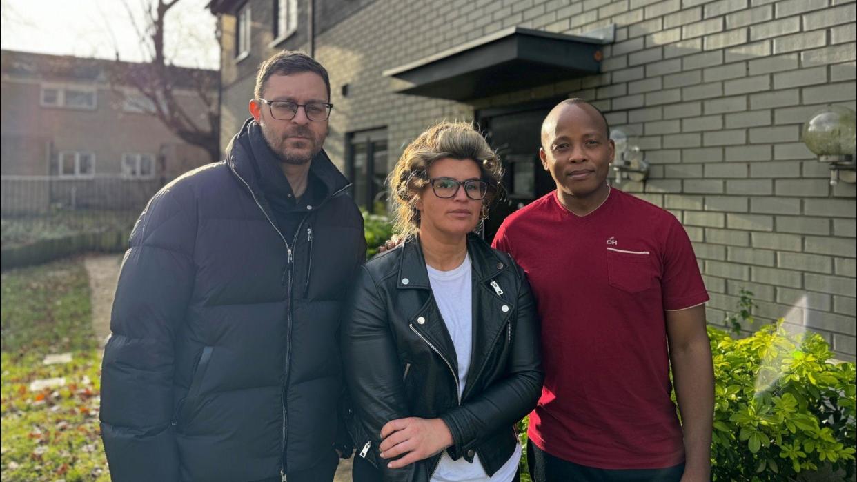 Homeowners Robert Altman, Georgina Bright and Themba Sikhosana stood outside one of the houses in Florence Close 