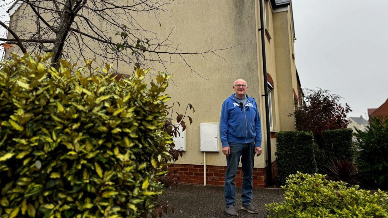 Robert Degavino stood outside his home in Bellway, with a black mark on the wall behind him 