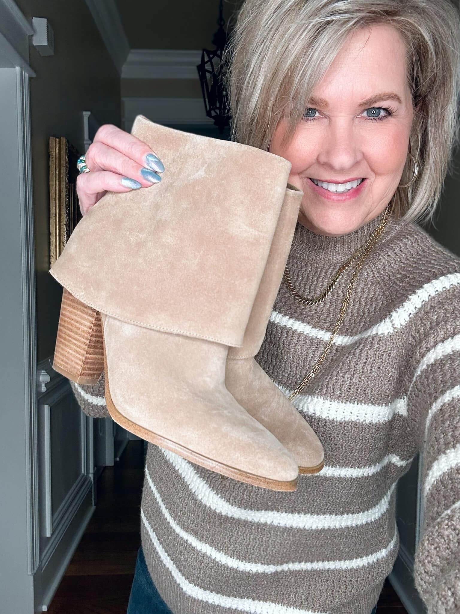 Tania Stephens wears a striped mocha sweater and ankle boots