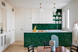 a kitchen with an emerald green tiled island