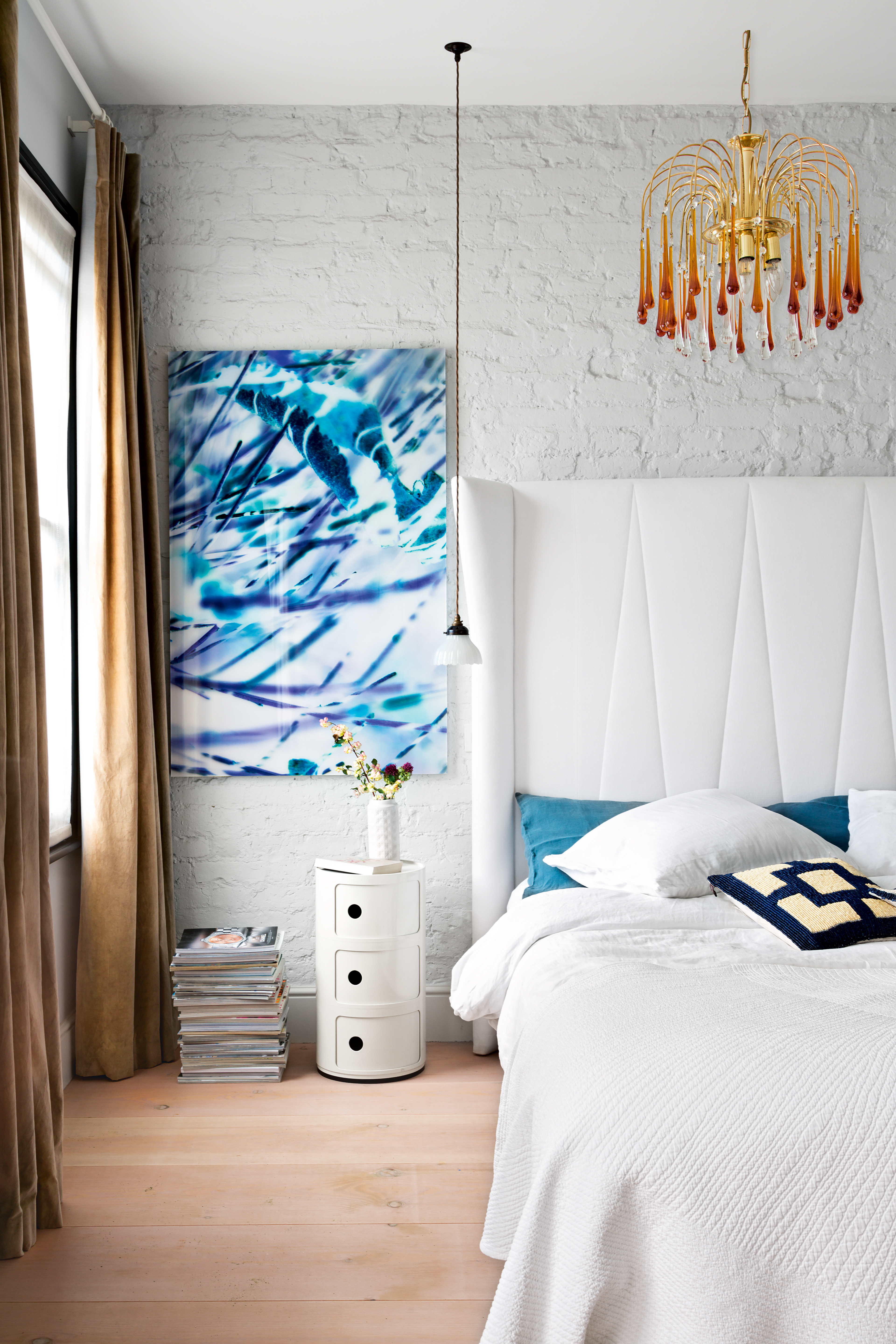 White and blue bedroom with exposed brick wall painted white