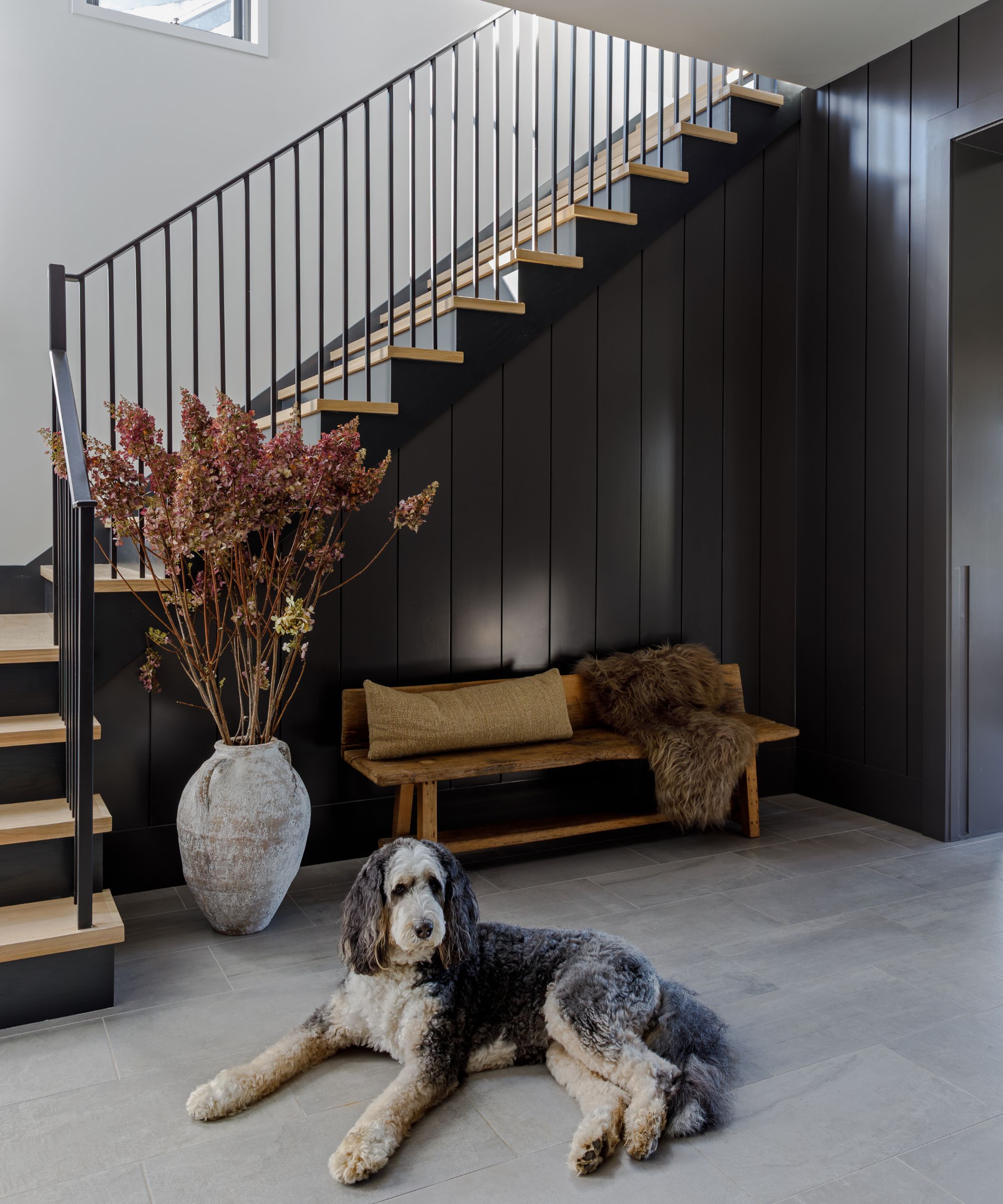 The entrance to an atmospheric boot room decorated with an antique wooden bench