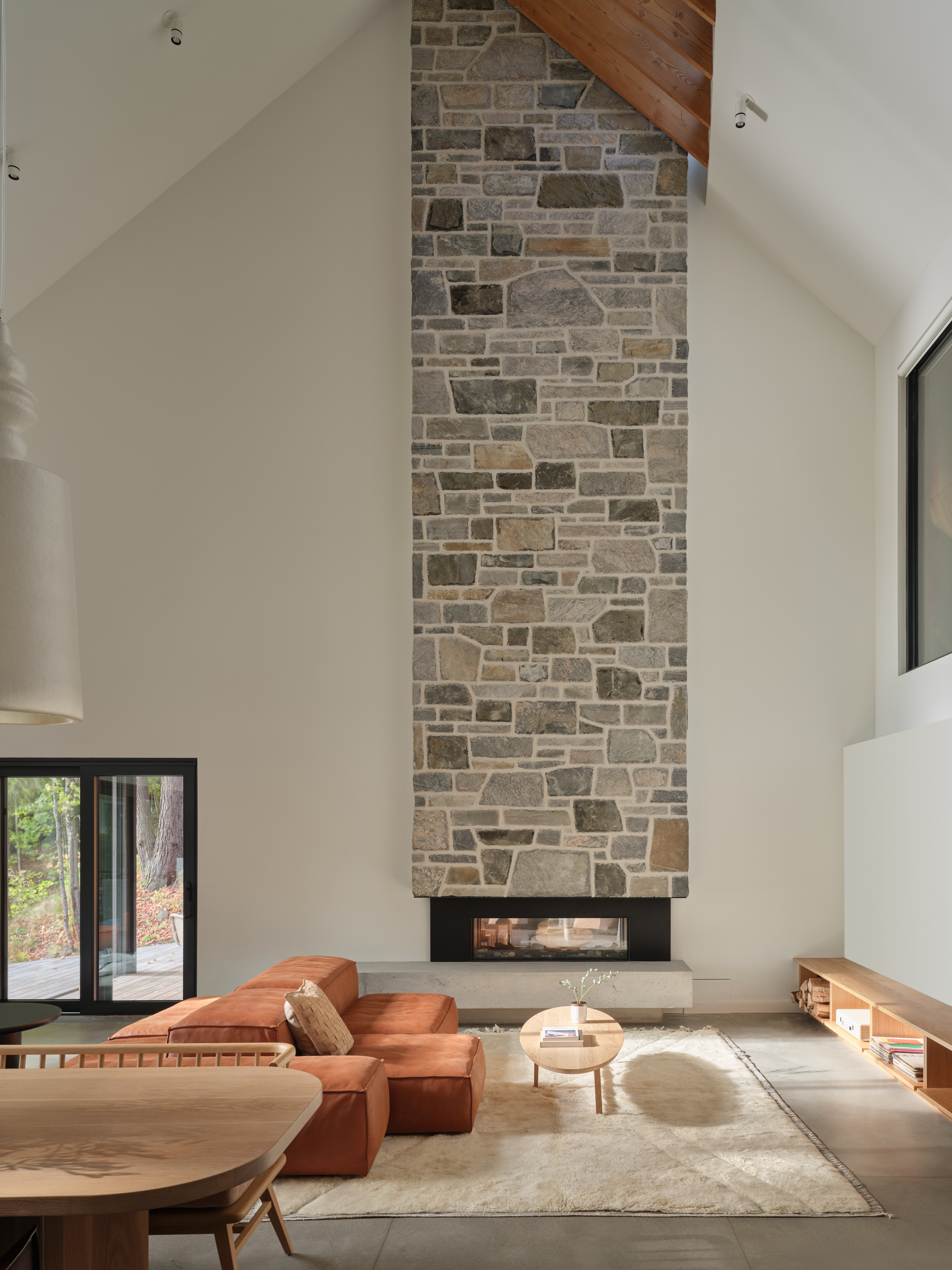 The main living space is twice as tall and features a stone-clad fireplace