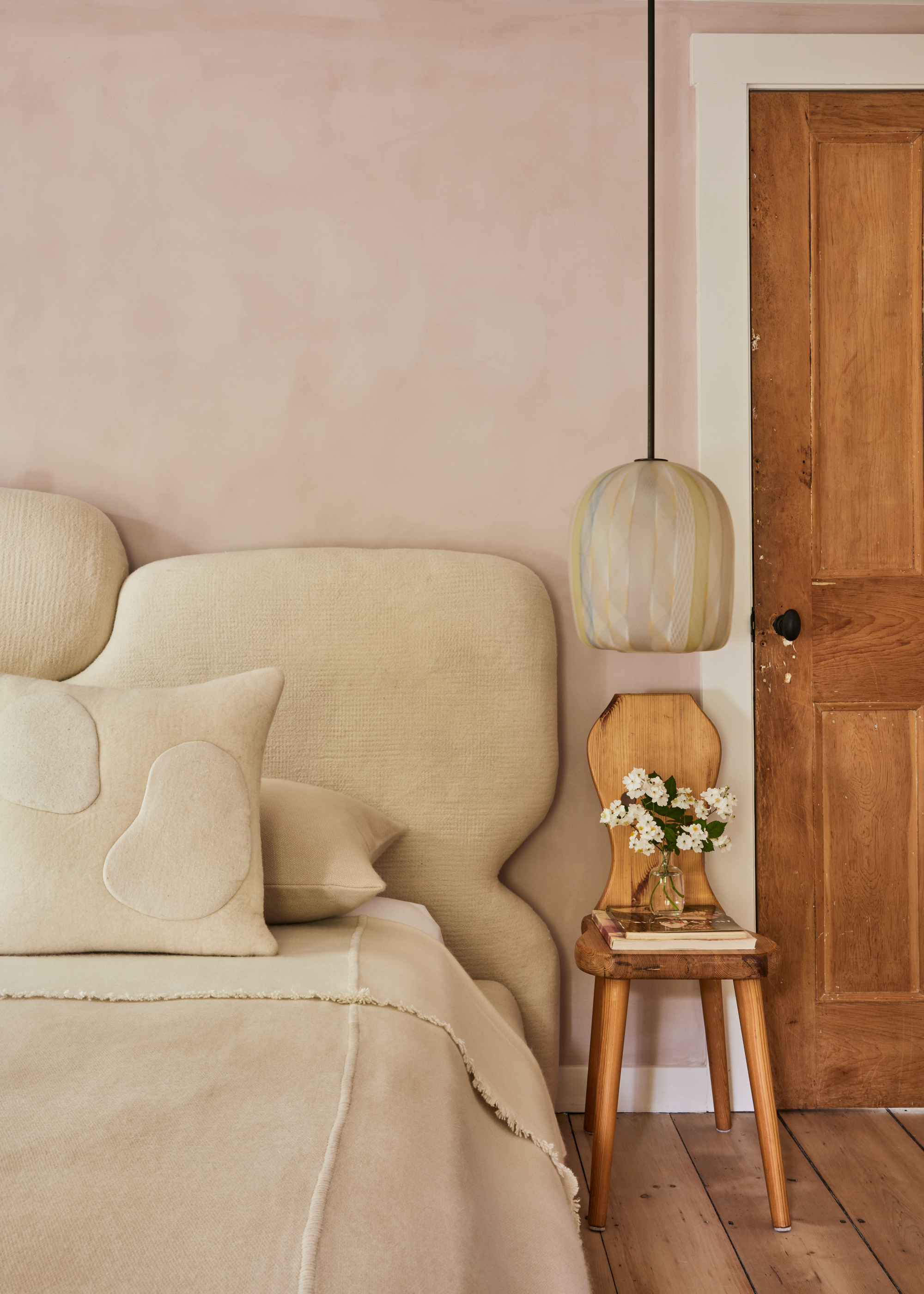 A bedroom in neutral colors with an upholstered headboard