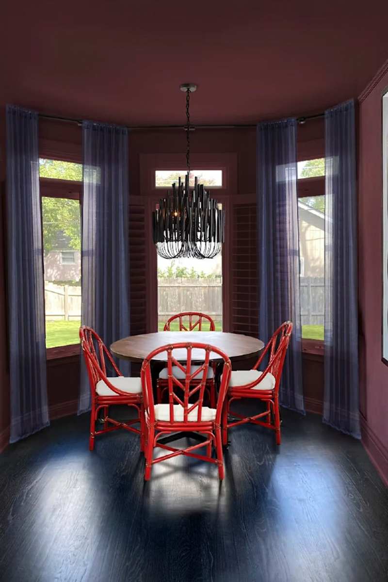 Dining area with colorful wall and orange chairs,