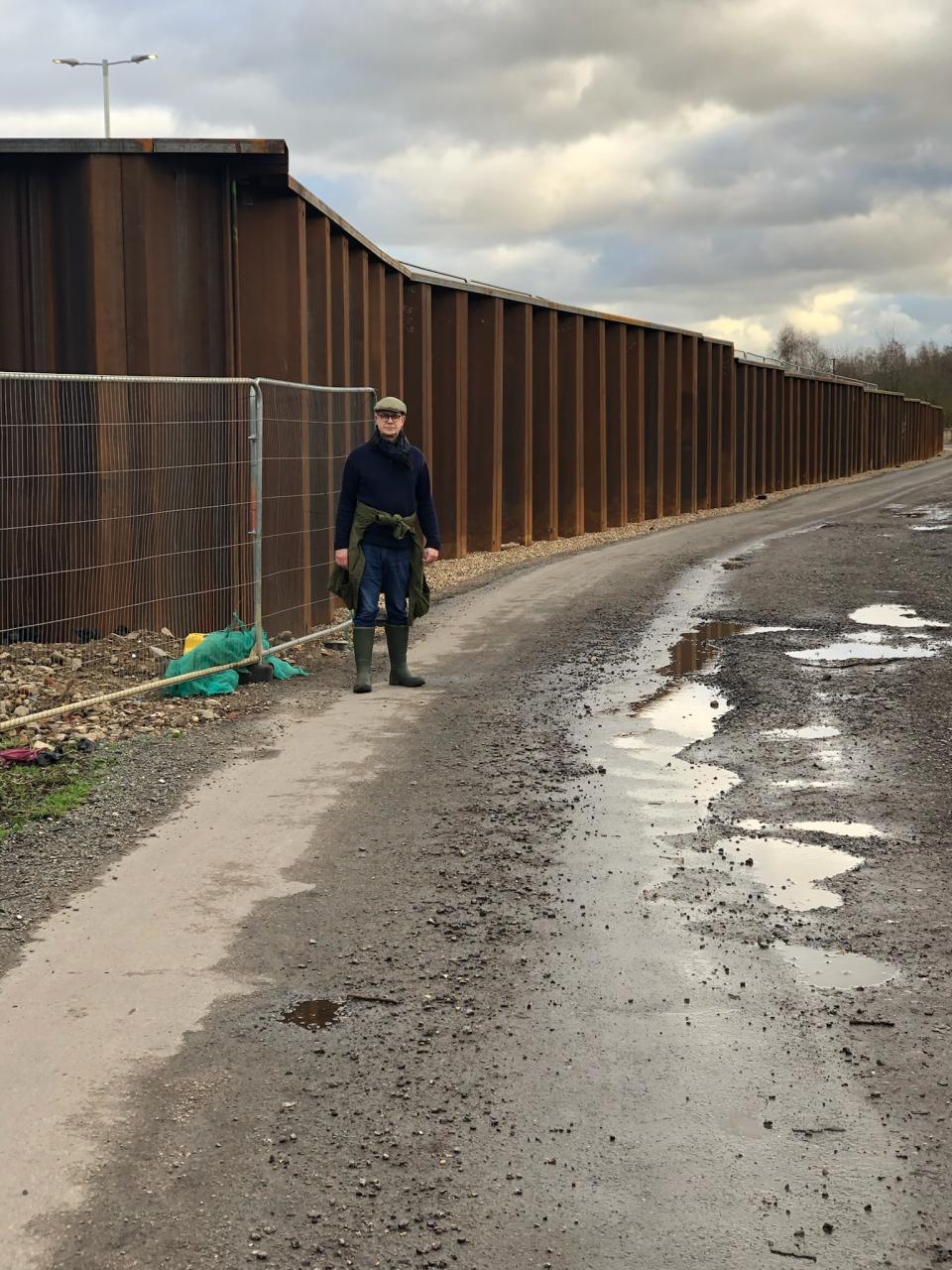 One person stands next to the steel sample wall of the parking lot