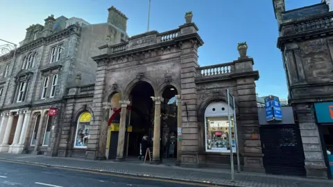 BBC An entrance to the Victorian Market on Academy Street in Inverness. The buildings are designed in Victorian style.