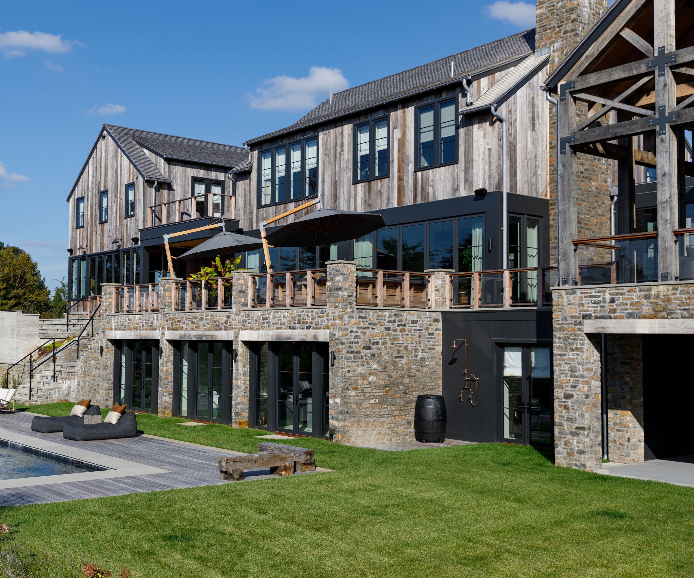 The exterior of a newly built mountain house made of reclaimed wood and rubble stone