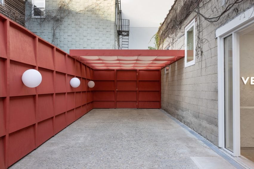 Outdoor courtyard, enclosed by red-capable panels and a pergola