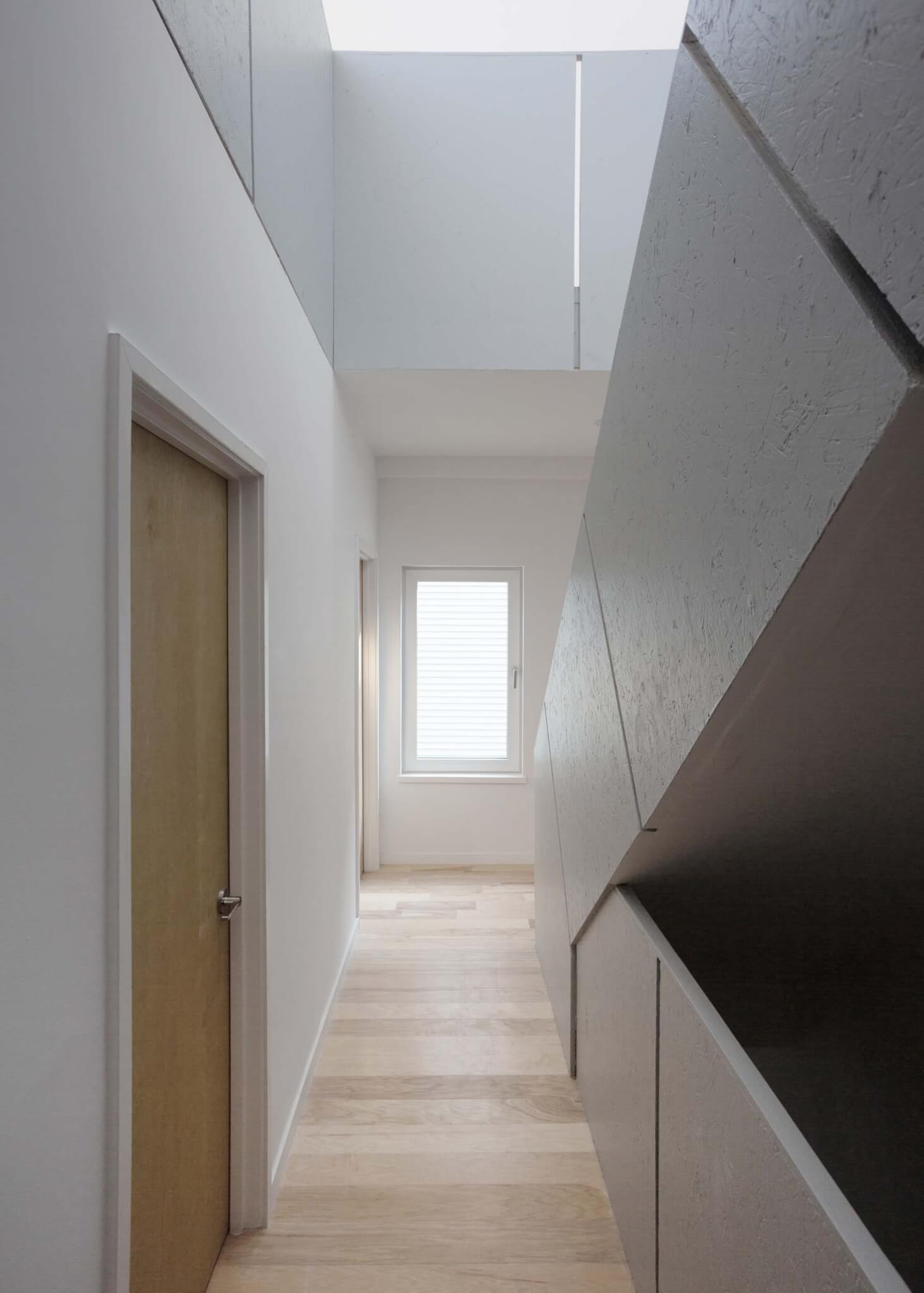 A mixture of materials inside, where there are white walls, wooden floors and doors