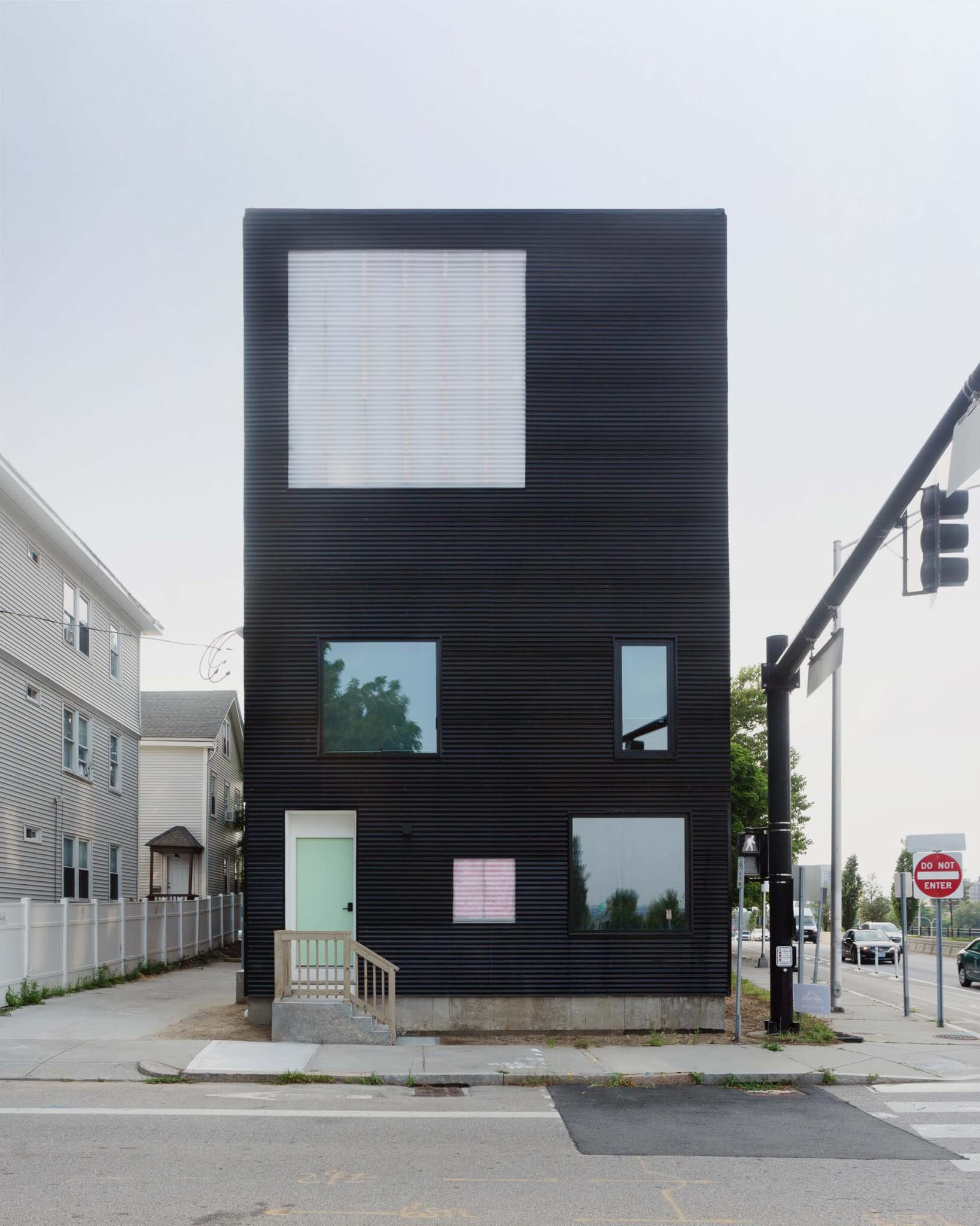 The house is covered with black corrugated metal