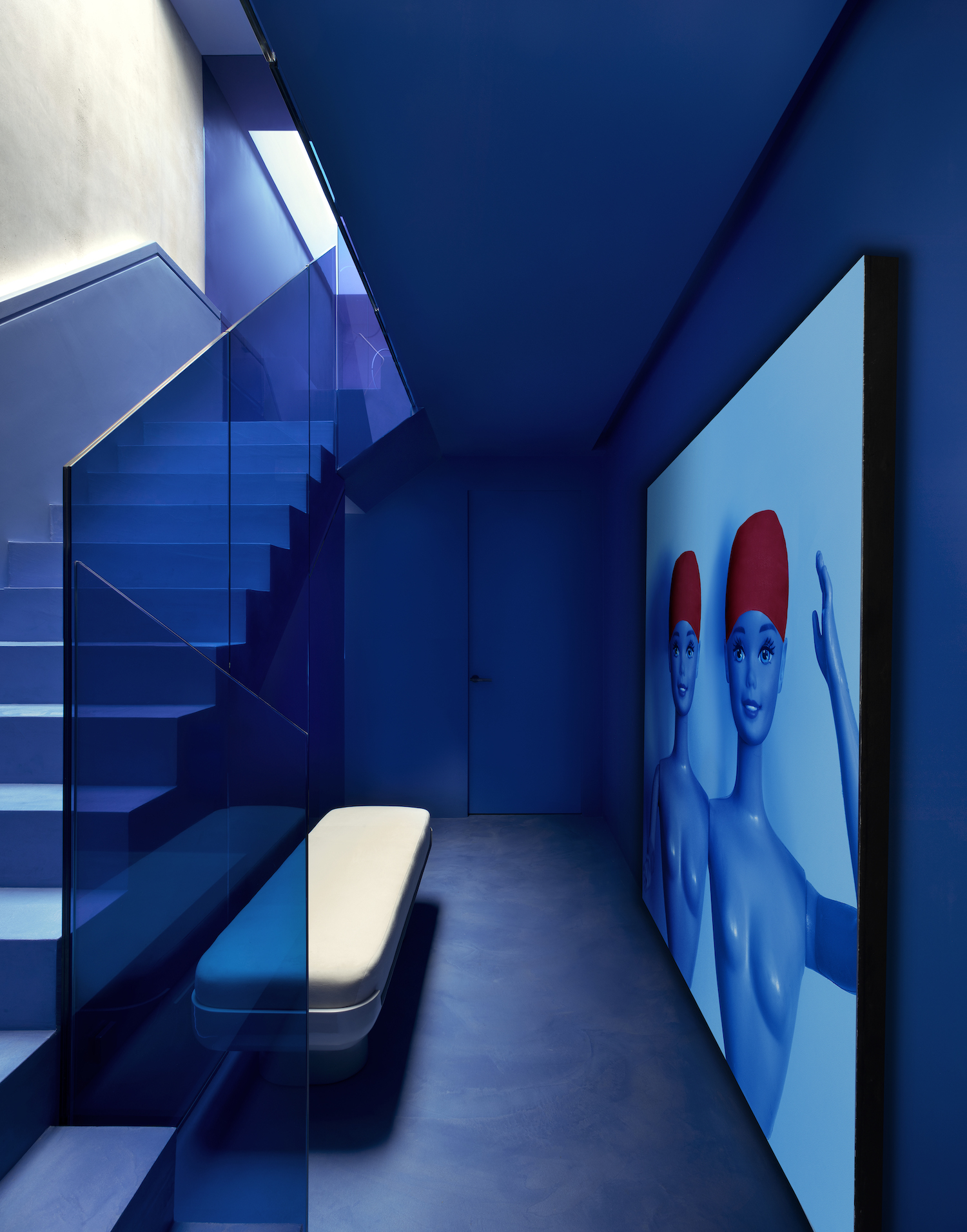 A royal blue staircase with a blue work of art with two barbie dolls