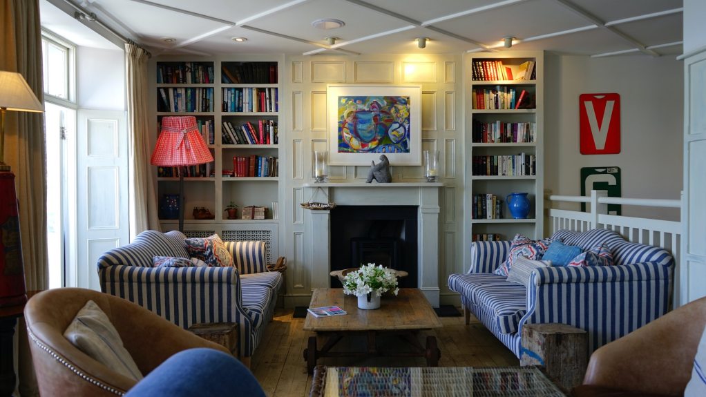 Outdated colorful living room with fireplace and high bookshelves