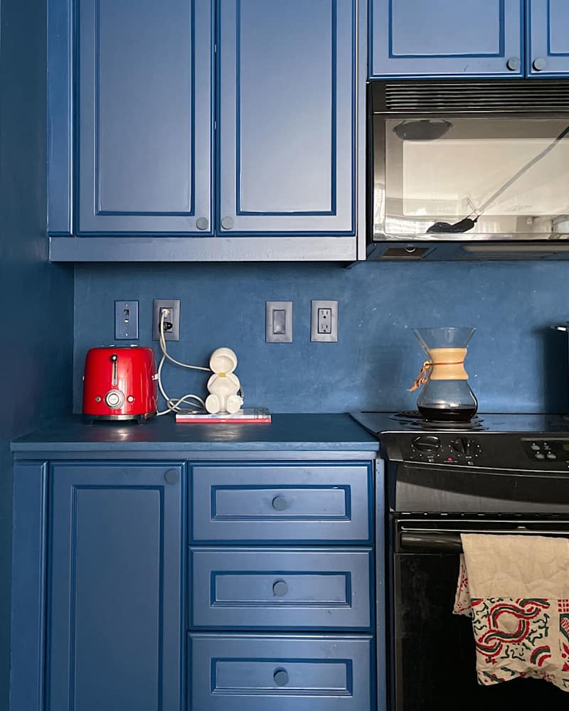 Blue -painted kitchen walls and cupboards in a newly renovated kitchen.