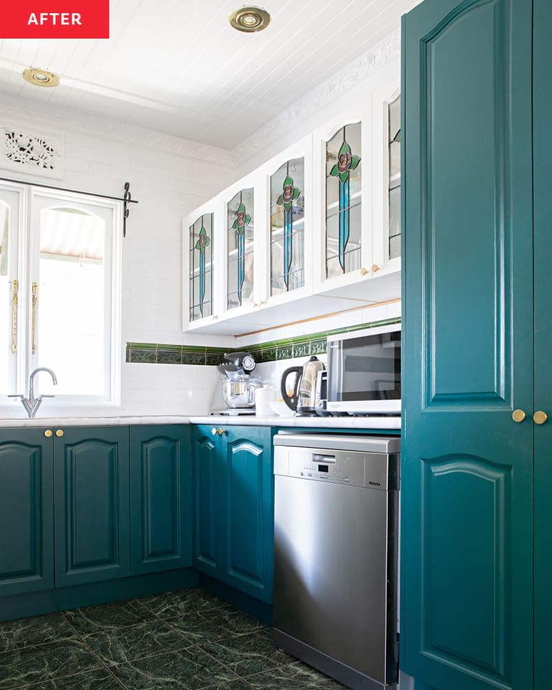 White kitchen after renovation with blue cupboards and colored glass accents