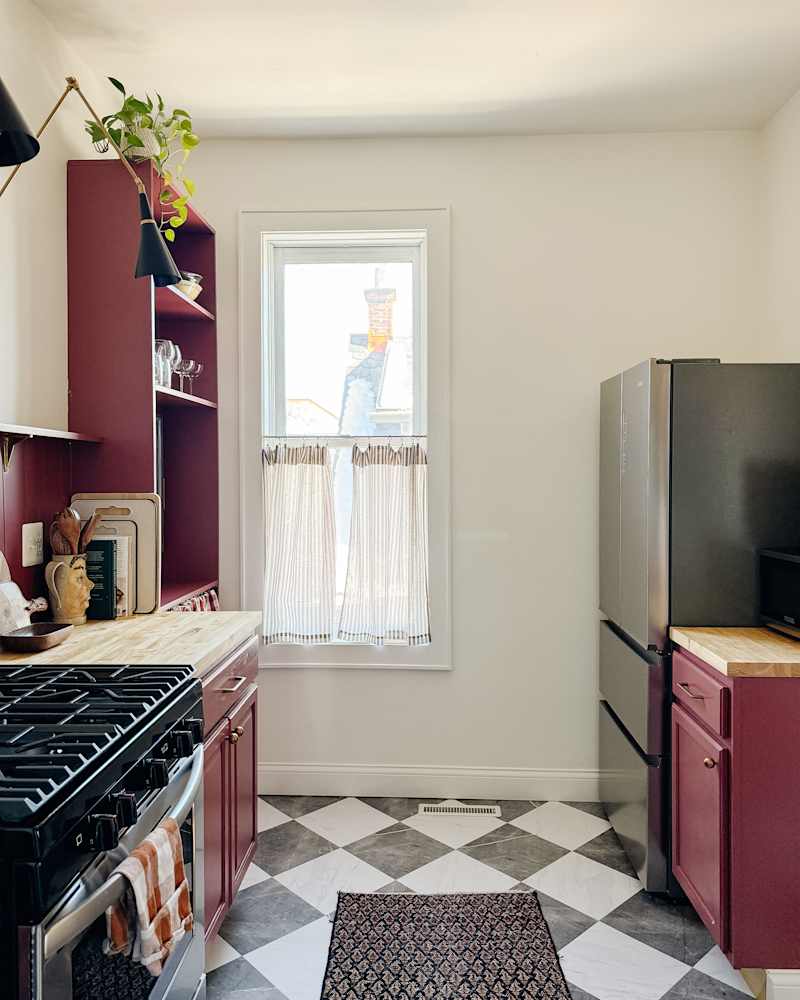 Small, green kitchen renovated and converted into burgundy -colored and red kitchen with chess board floor.