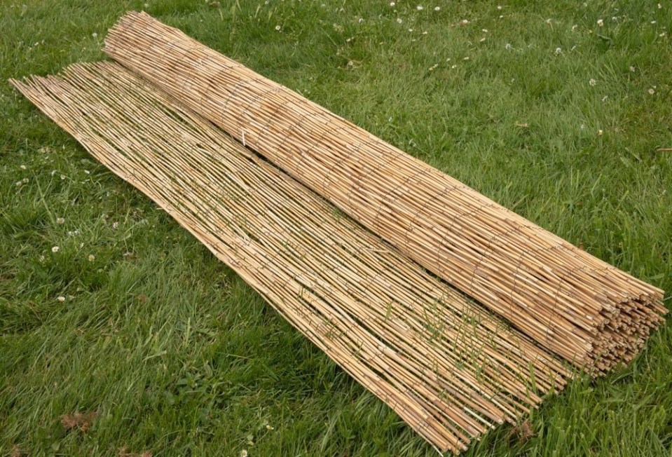 Rolled reed fences on the grass.