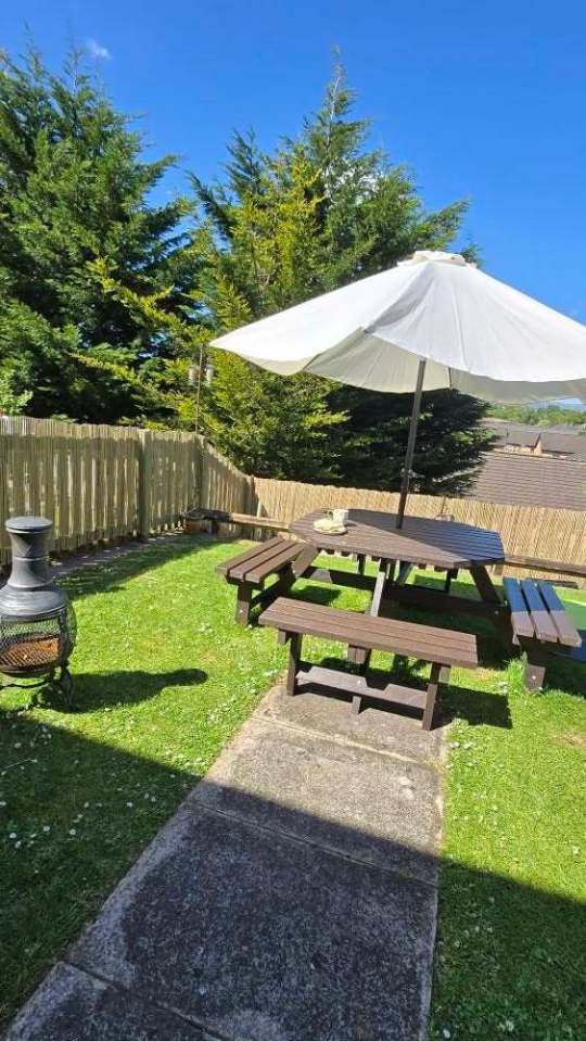 Garden terrace with a picnic table and umbrella.