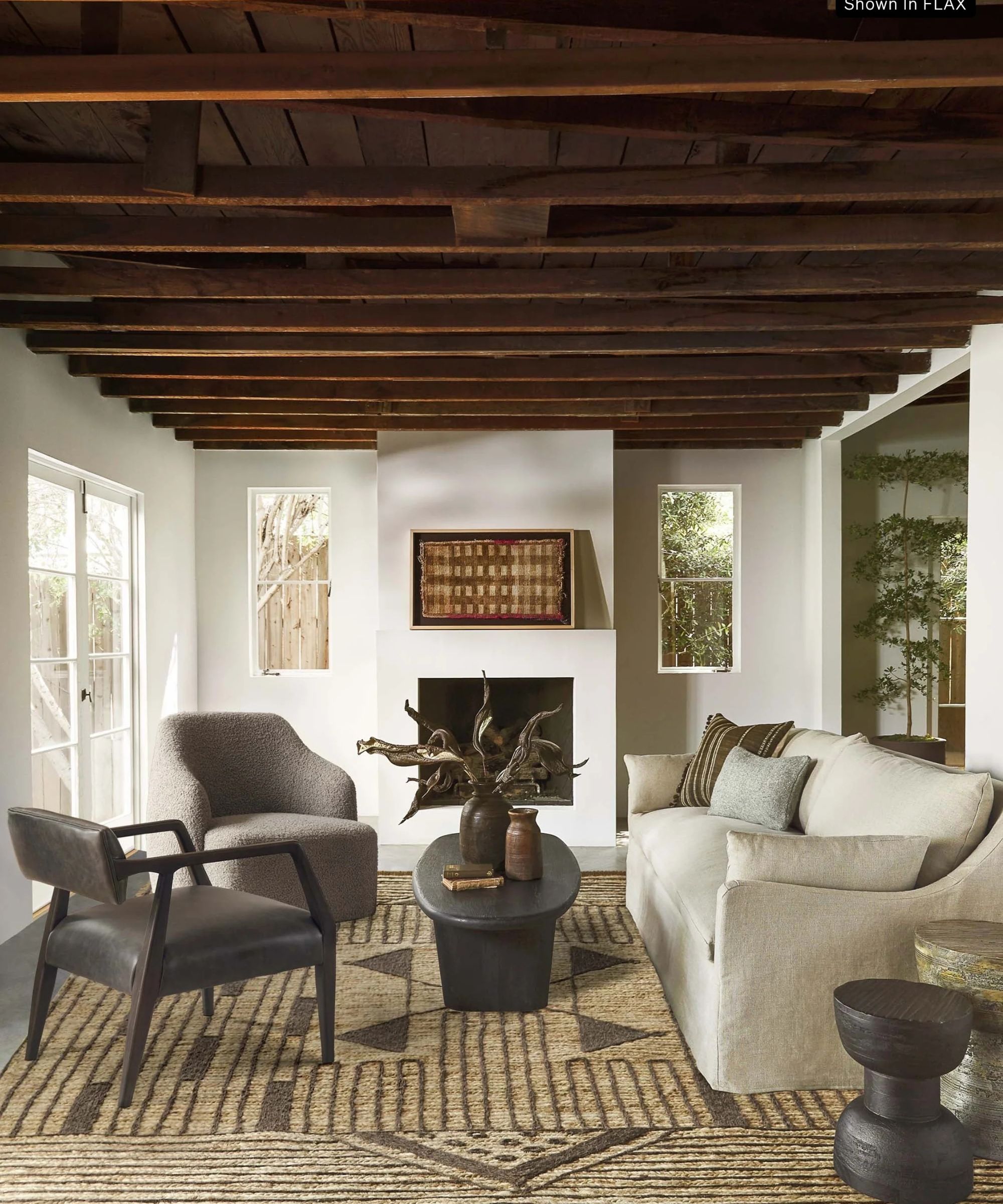 White living room with wooden beams and cream -colored slip sofa