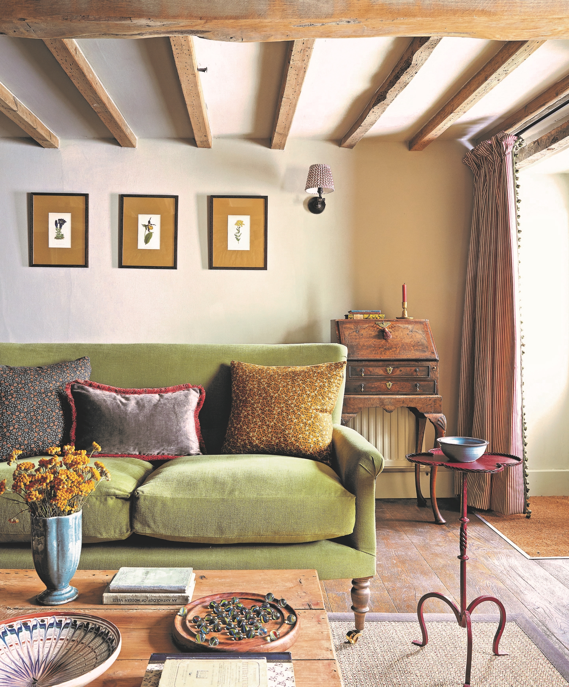 Living room with a green sofa, wooden beam and wooden office