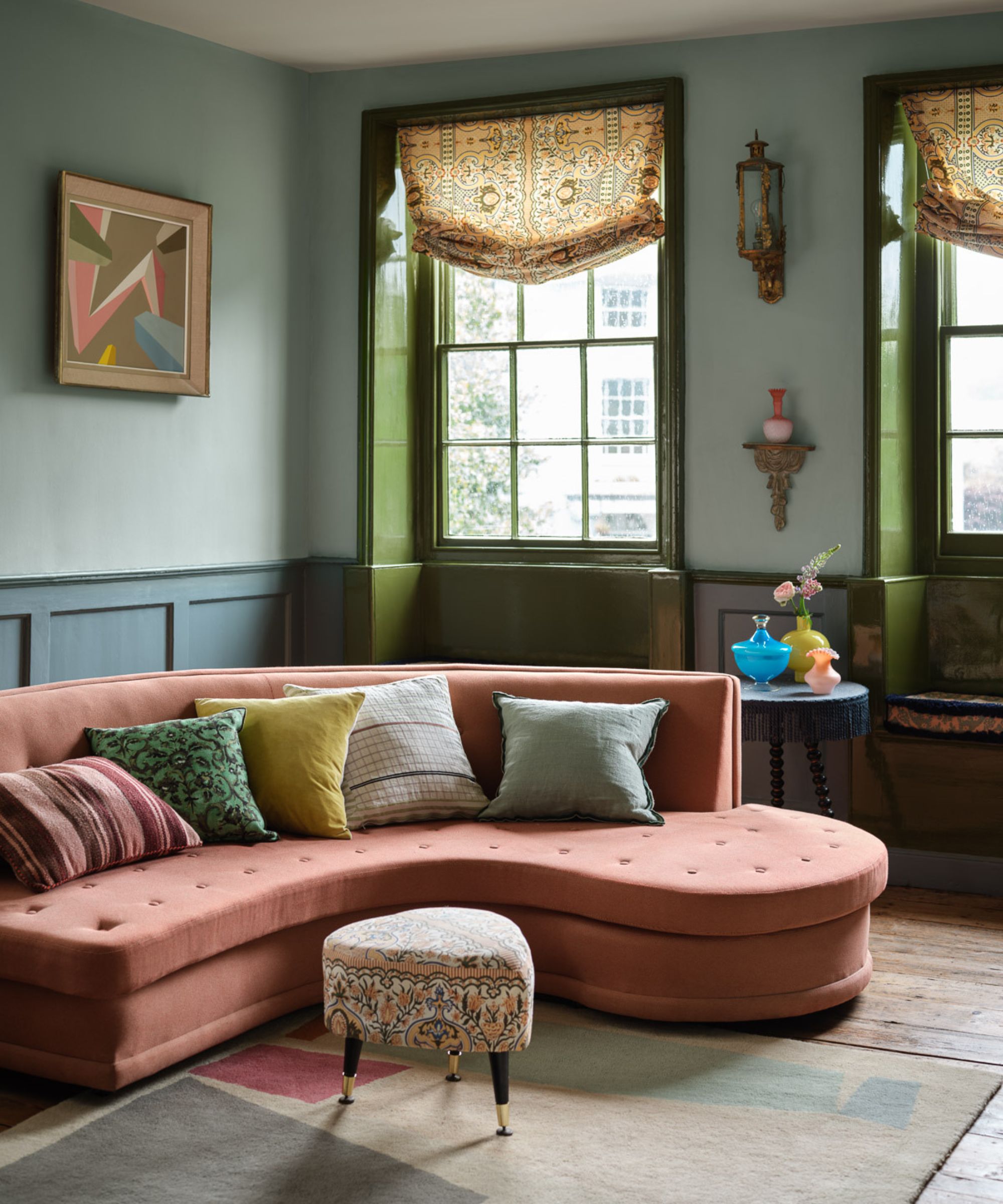 Green and blue living room with pink sofa