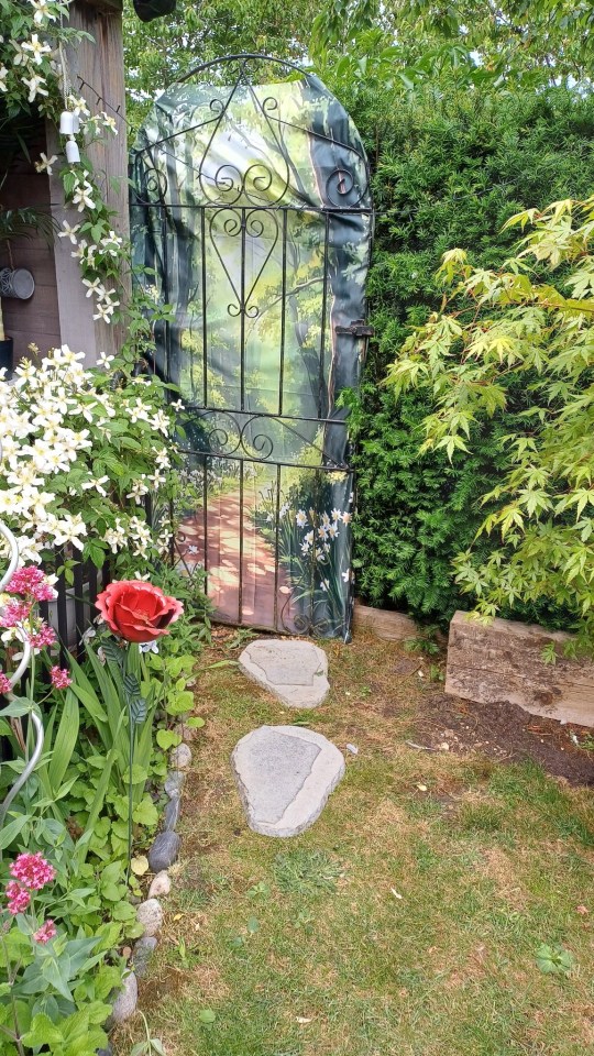 Garden gate with painted forest scene.