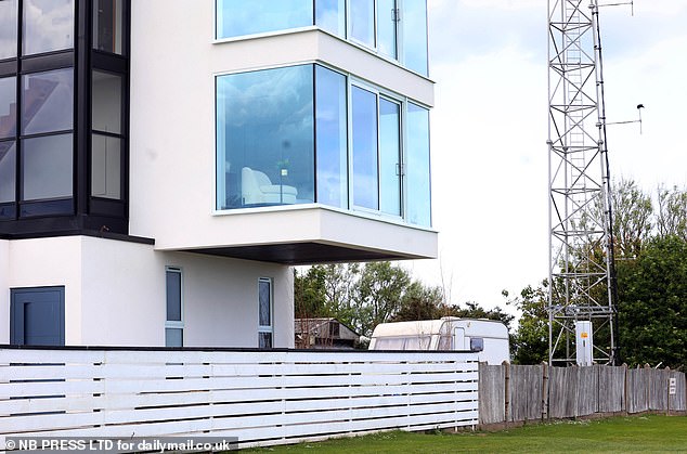 The locals suggested that the house may not meet any building regulations, since external glass doors are on two floors without balconies (shown).