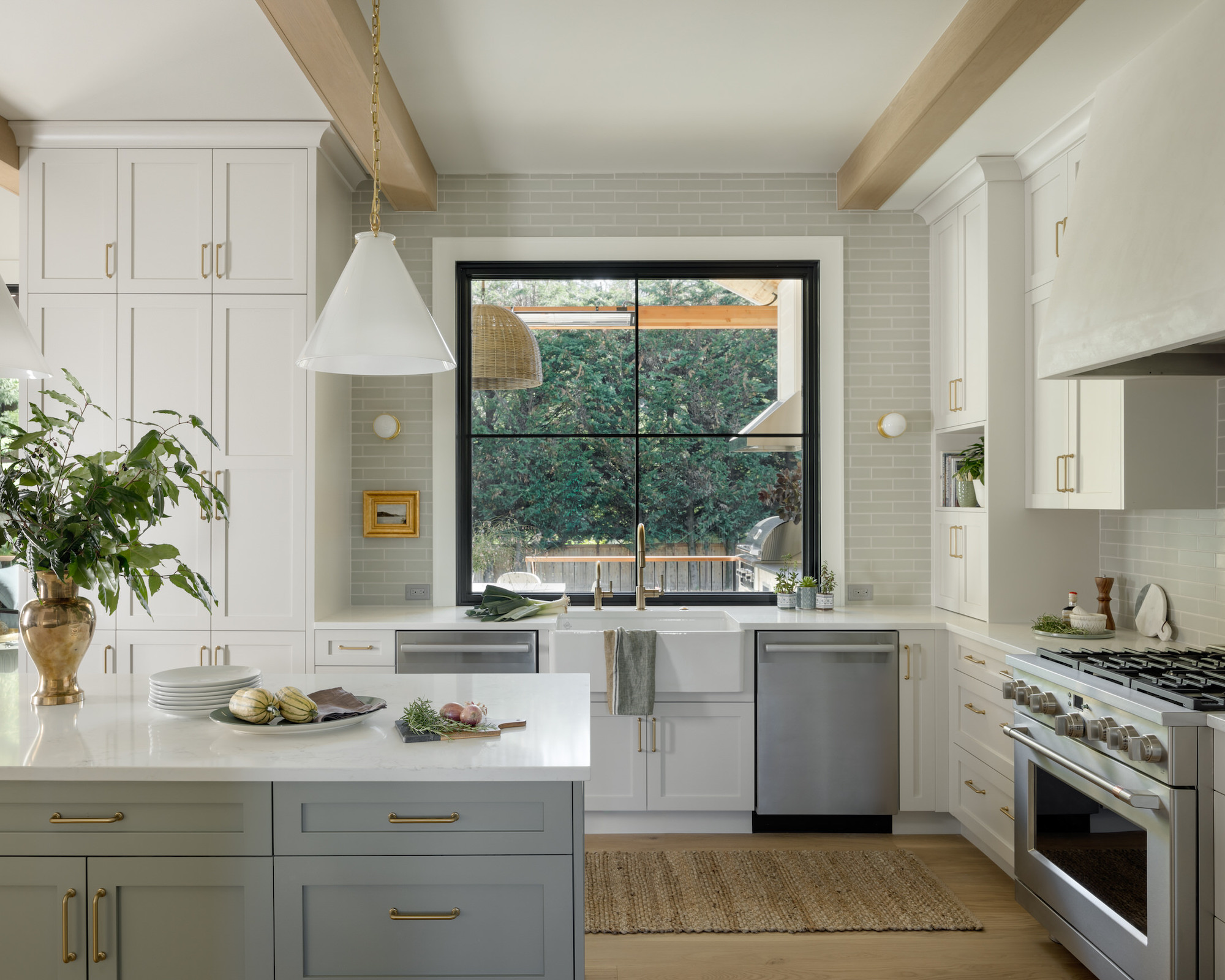 Kitchen with neutral cupboards and gray island, range and white worktops