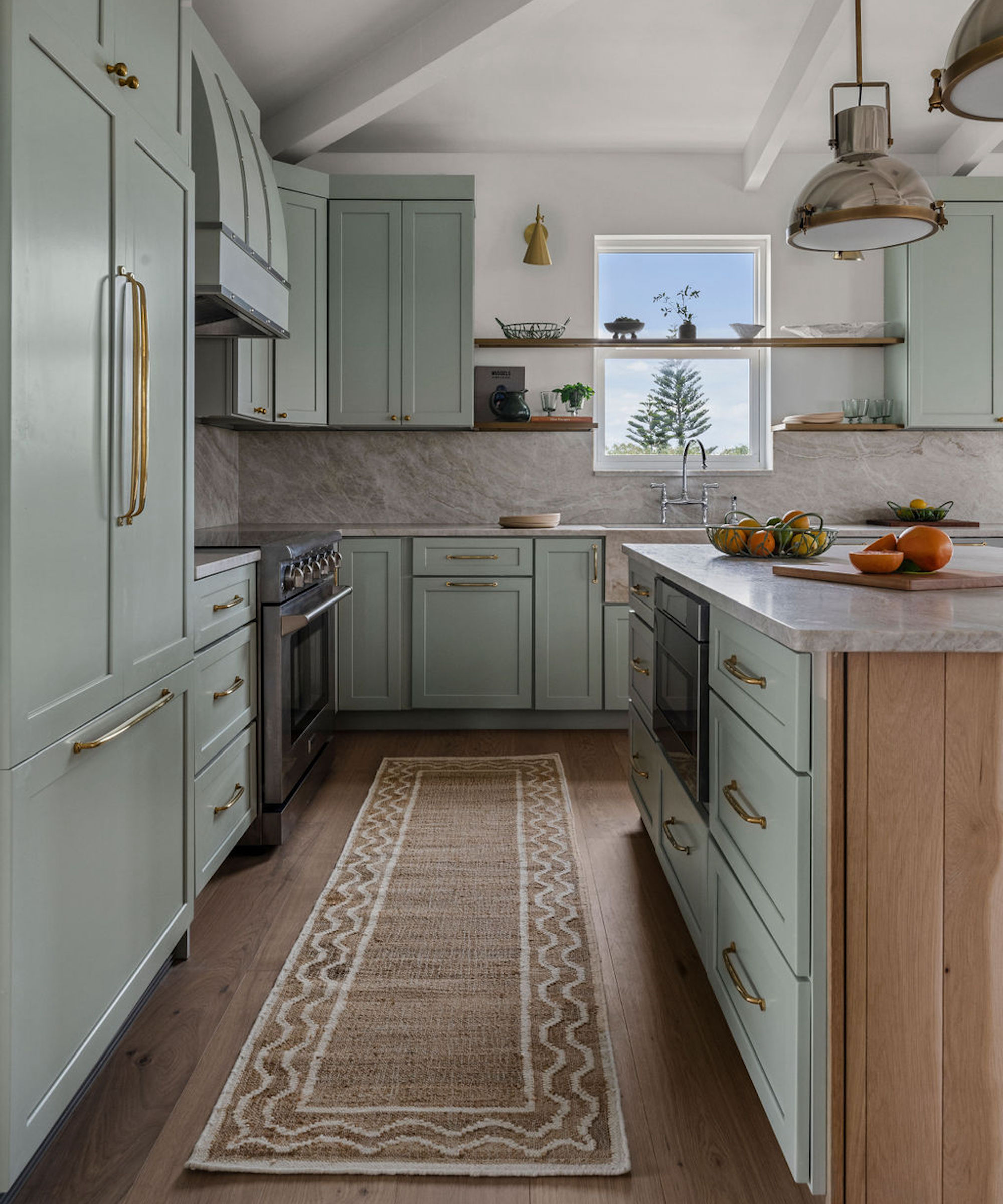 Kitchen with gray cupboards and island, carpet, range and trailer light over island