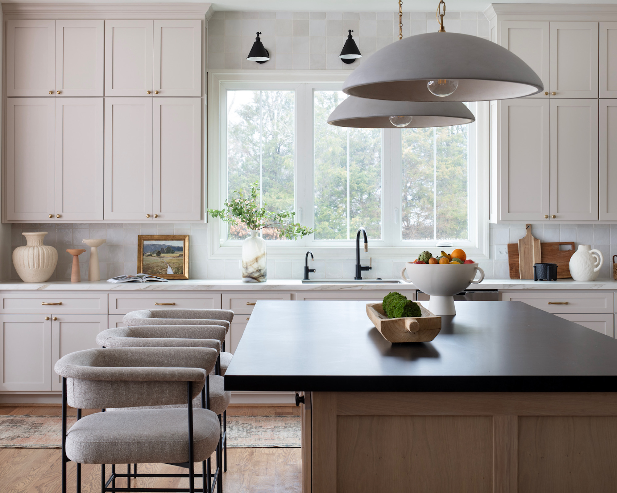 Kitchen with beige cupboards, Wood Island with beige padded bar stools and trailer lights and black bar stools