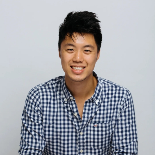 Picture of a man in a blue and white check shirt in front of a light gray background.