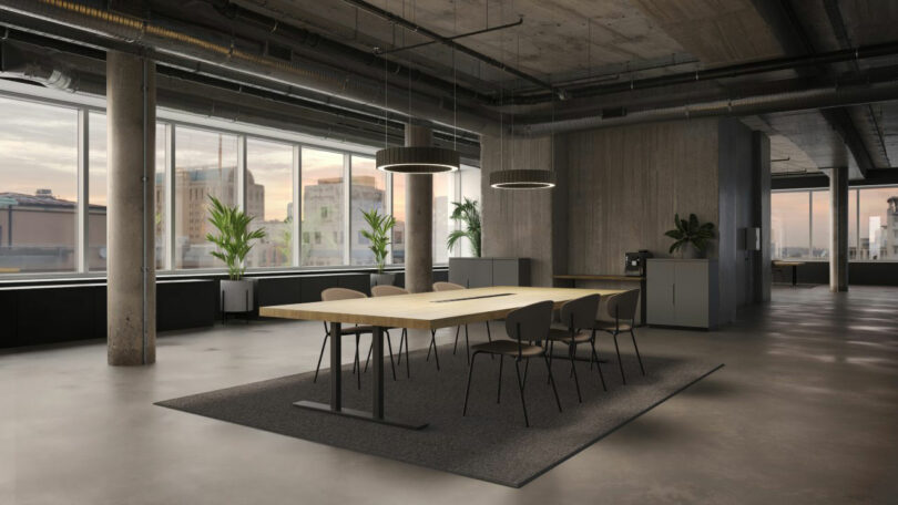A modern conference room with a large wooden table, six chairs, potted plants, circular ceiling lights and large windows with a view of the city building.