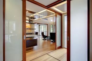 Interior in a flexible house in Brisbane with sliding frost glass doors, open shelves and wooden floors that are designed for life with several use.