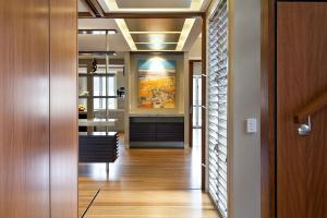 Inner floor of a post -war home in Indooroopilly, which shows wooden areas, works of art and open visual lines through several residential areas that are designed for flexible use.