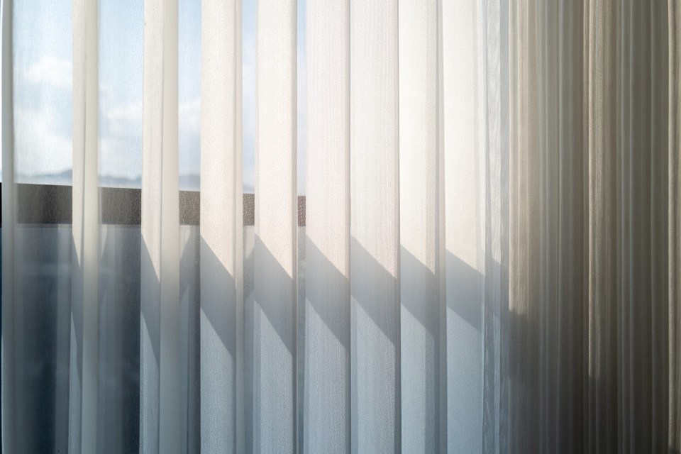 Sunlight seems through sheer curtains.
