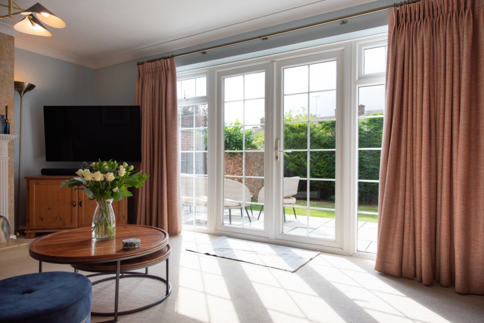A general interior of white UPVC plastic -terrace doors in the garden with a table and chairs out of a lounge