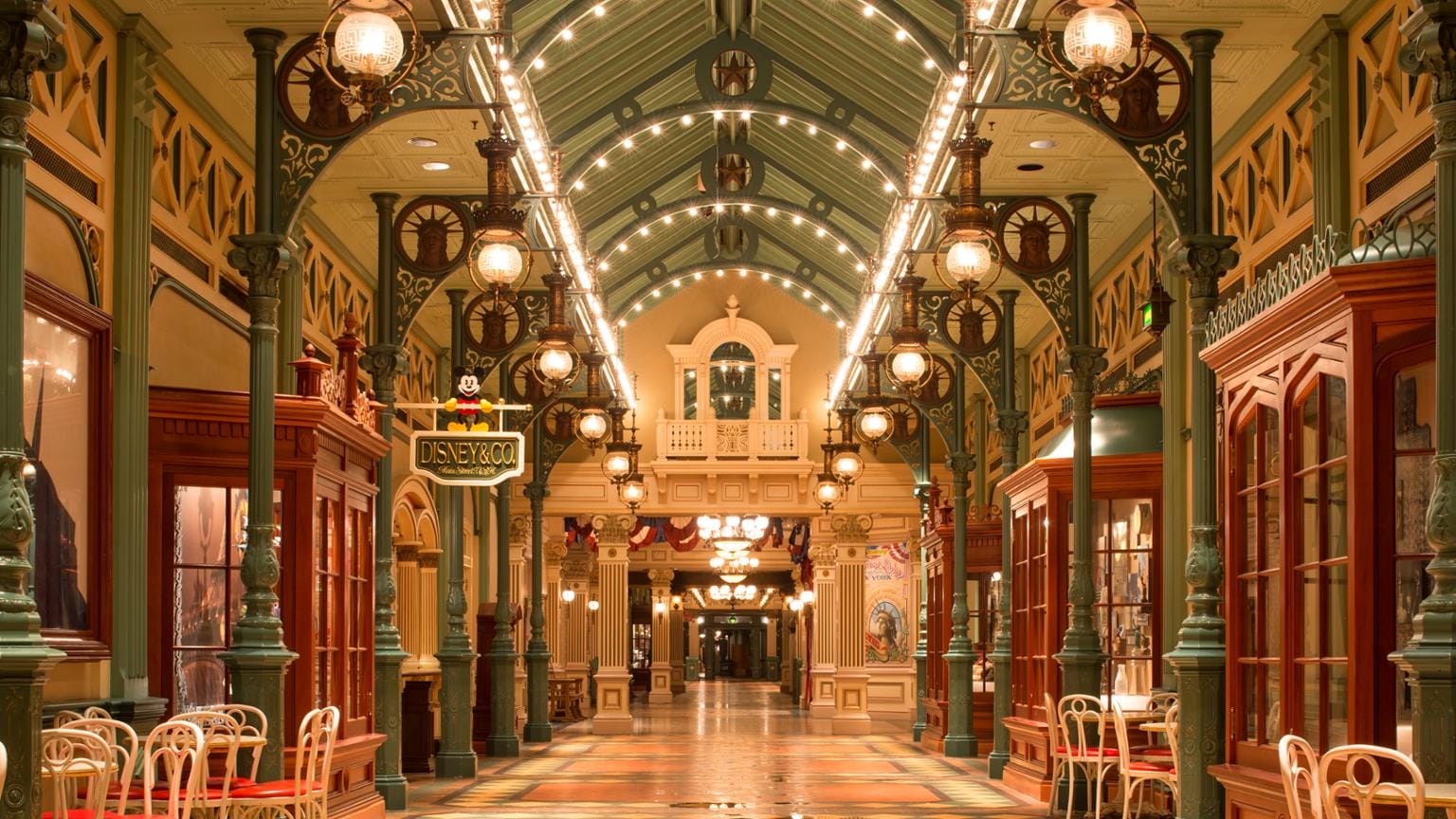 Zulate inner arch arcade with vintage lights, skylights, arched ceiling and empty tables and chairs along the sidewalk.