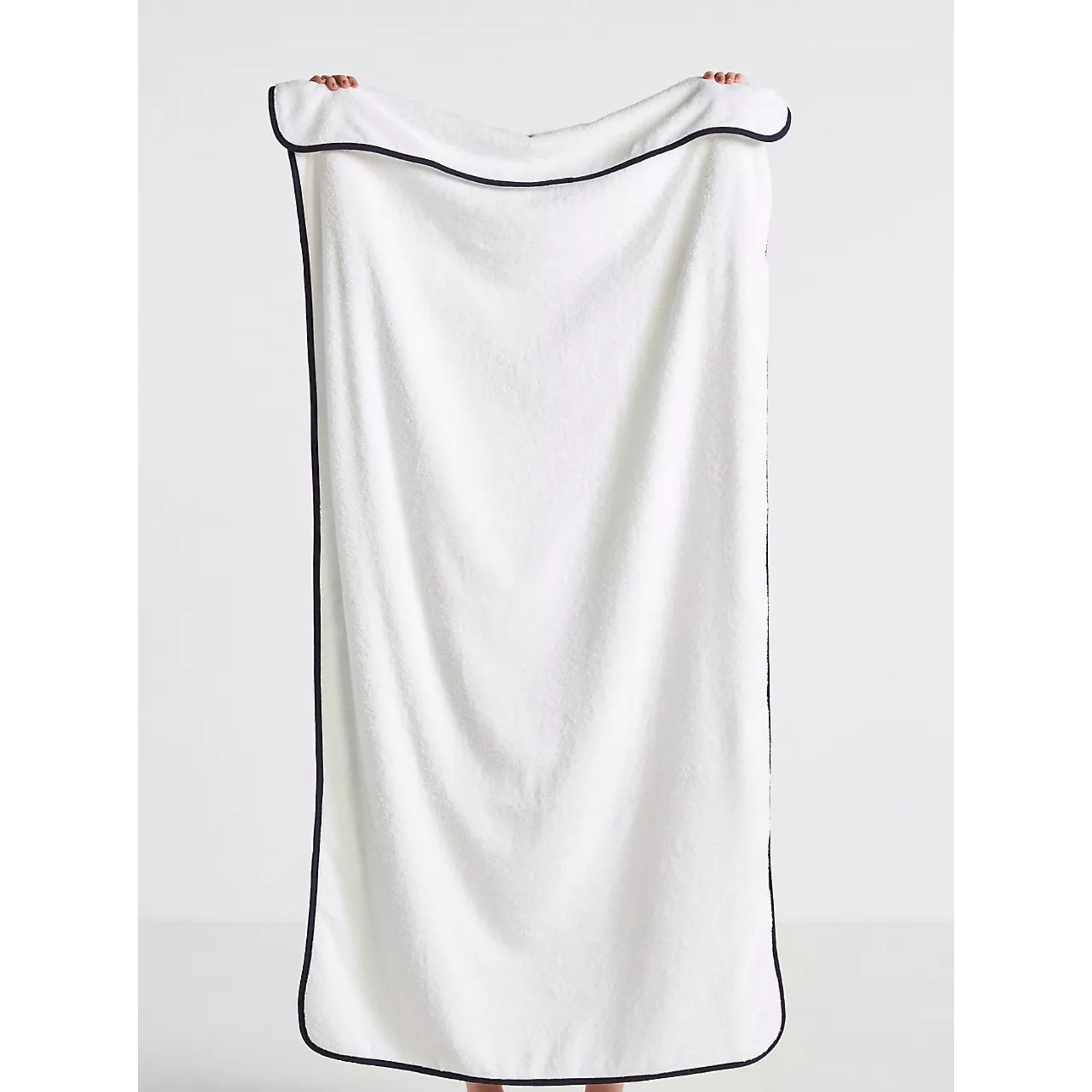 A white cotton cloth with black pipe edges.