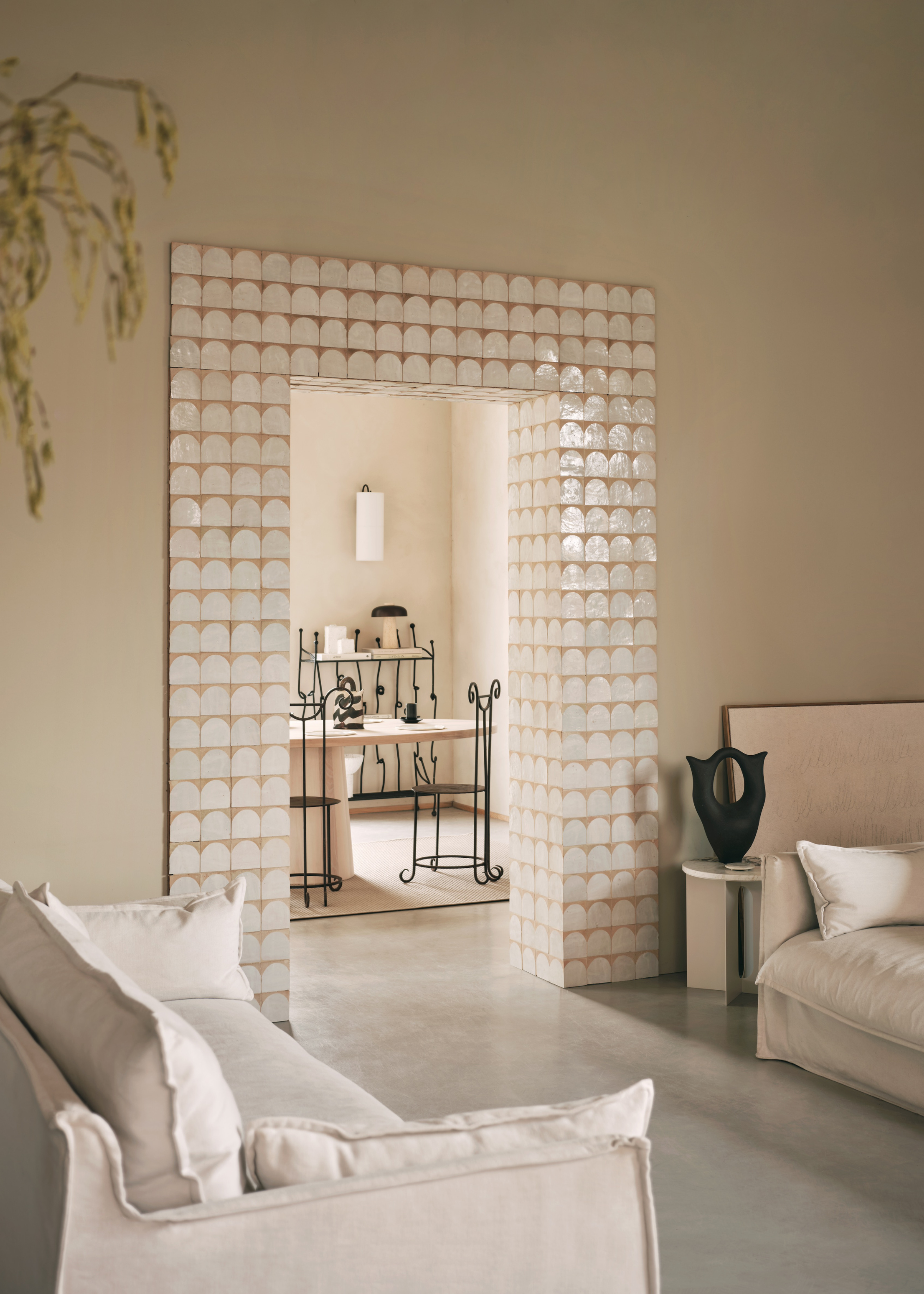 A light neutral room with a tiled door in a living area with two sofas and a view of the dining area