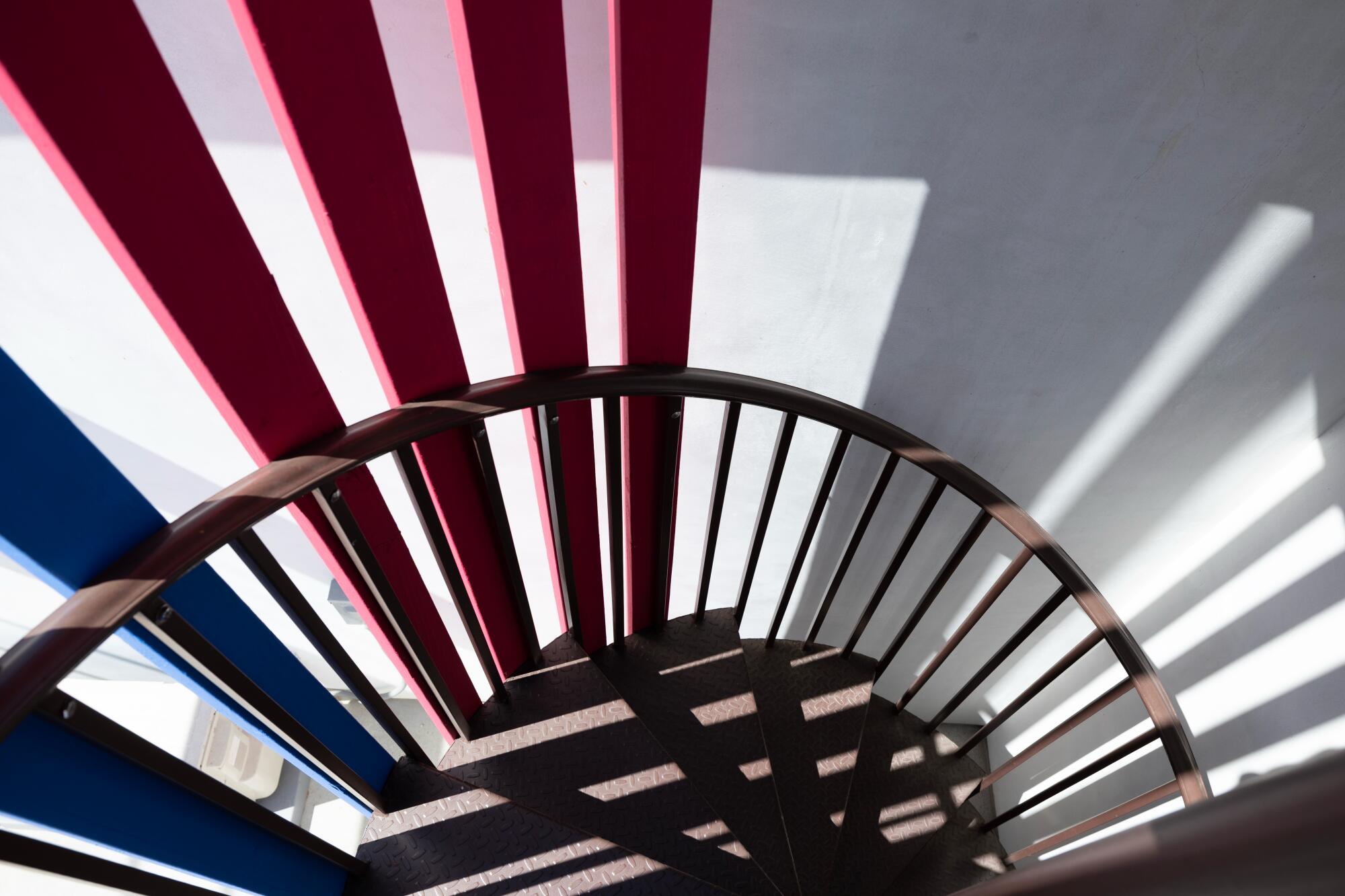 The spiral staircase painted red and blue outdoors.