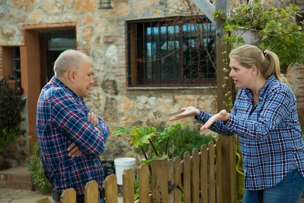 Angry woman who strives with her male neighbor and speaks through a wooden fence
