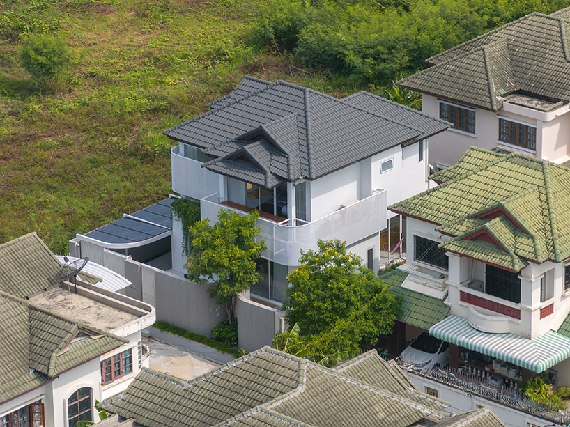curved textile facades wrap the reborn house in Bangkok Village, which soft
