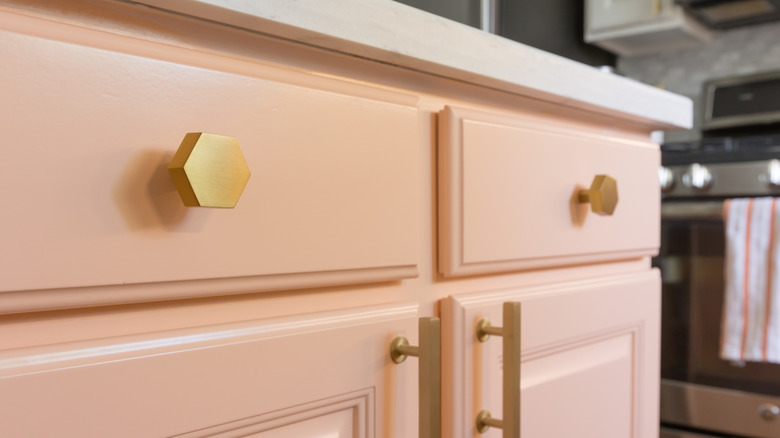 Pink kitchen cabinet with golden hardware