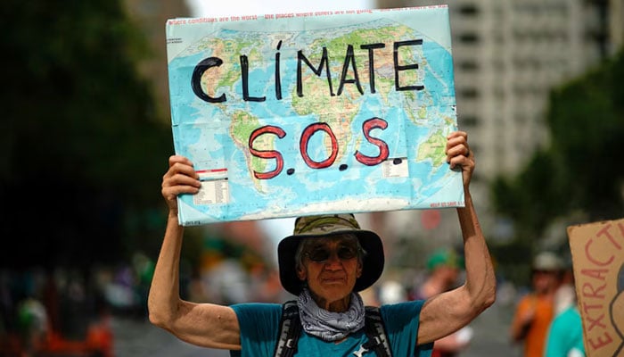 A man has a sign when activists mark the beginning of the climate week in New York during a demonstration in which the US government took measures against climate change and the use of fossil fuels in New York, New York, USA, September 17, 2023 - Reuters - Reuters.