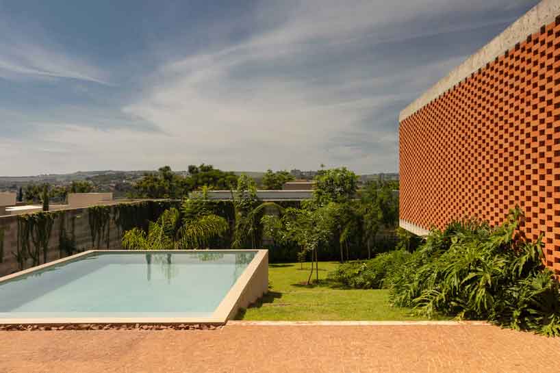 Perforated brick facade punctures Fernanda Padulas concrete house in Brazil